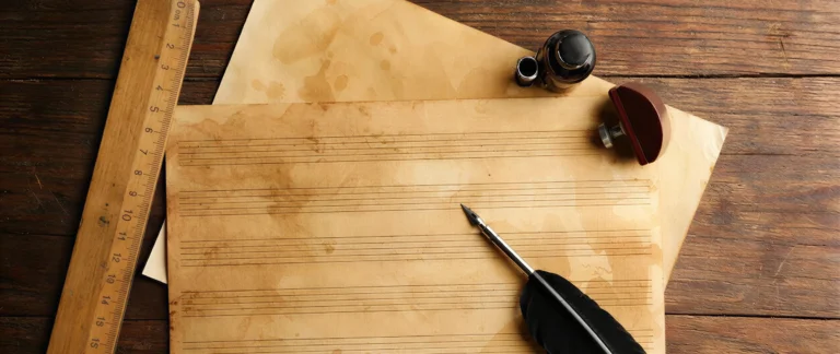 blank hand-ruled music staves on aged paper with a ruler, quill and ink