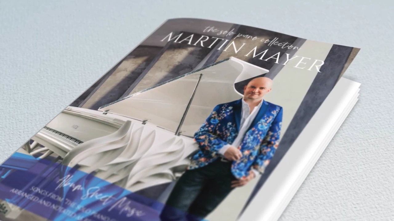 The printed cover of The Solo Piano Collection by Martin Mayer, showing the composer leaning on a white grand piano.